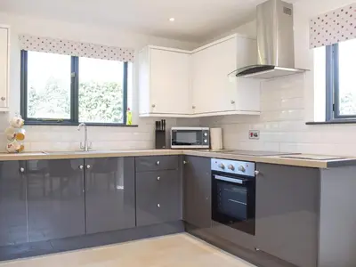 a kitchen with white cabinets and a stove top oven at Hill View Lodge in Knucklas