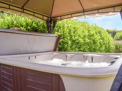 a bathtub with water in it sitting under an umbrella at Hill View Lodge in Knucklas
