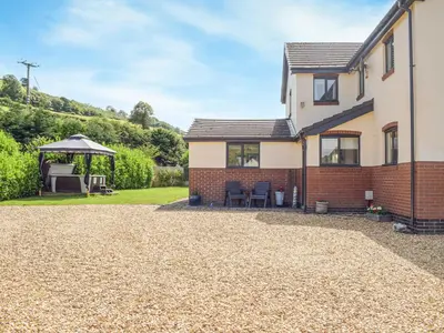 a house with a gravel driveway and a gazebo at Hill View Lodge in Knucklas