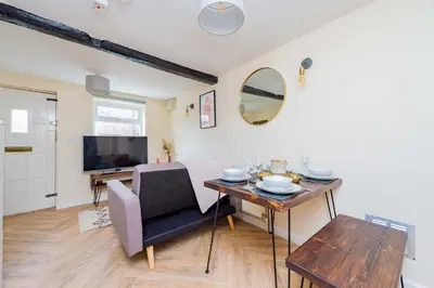 a living room with a dining table and a television at Coton Hill Shrewsbury Cottage in Shrewsbury