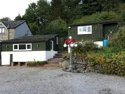 a house with a santa claus on top of a pole at Poplar Lodge, Dee Valley Stays - cosy microlodge with detached private shower & WC in Corwen
