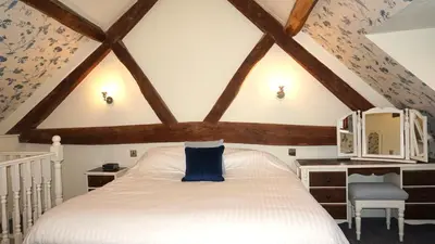 a bedroom with a white bed with a blue pillow at Wheat Cottage - 5* Cyfie Farm with private covered hot tub in Llanfyllin
