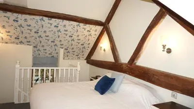 a bedroom with a white bed and blue floral wallpaper at Wheat Cottage - 5* Cyfie Farm with private covered hot tub in Llanfyllin