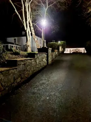 a street light next to a stone wall at night at YR HEN FICERDY in Aberystwyth