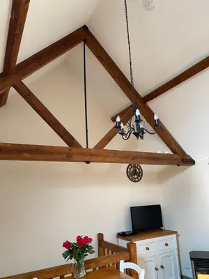 a chandelier hangs from the ceiling of a dining room at Stable Cottage, Bishops Castle in Bishops Castle