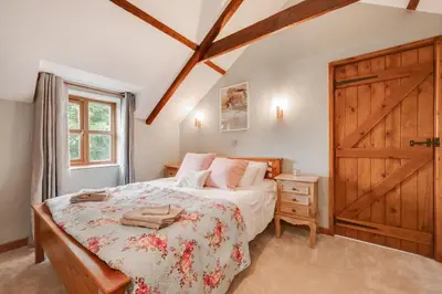 a bedroom with a bed and a wooden door at 3 Bed in Aberaeron oc-bow315 in Cross Inn