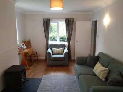 a living room with a couch and a chair and a window at Avryn - Delightful 3 bedroom cottage with stunning vistas in Mainstone
