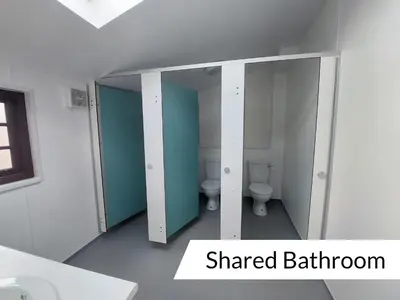 a bathroom with two toilets and a mirror at Cwm Clyd - Carthouse in Rhayader
