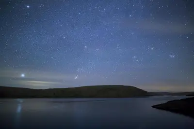 a starry sky over a body of water at night at Cwm Clyd - Carthouse in Rhayader