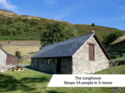 a small stone building in the middle of a field at Cwm Clyd Longhouse in Llanwrthwl