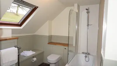a bathroom with a shower and a toilet and a sink at Barley Cottage - 5* Cyfie Farm with log burner and private covered hot tub in Llanfyllin