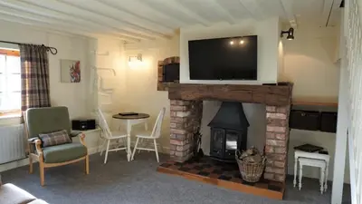 a living room with a fireplace with a television on top at Barley Cottage - 5* Cyfie Farm with log burner and private covered hot tub in Llanfyllin
