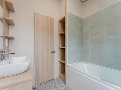 a bathroom with a white tub and a sink at Cledan in Aberaeron