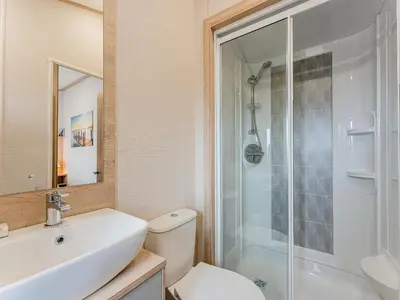a bathroom with a toilet and a sink and a shower at Cledan in Aberaeron