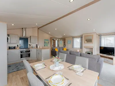 a living room with a dining table and a kitchen at Cledan in Aberaeron