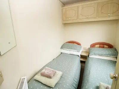 two twin beds in a small room with at 6 Old Orchard in Much Wenlock