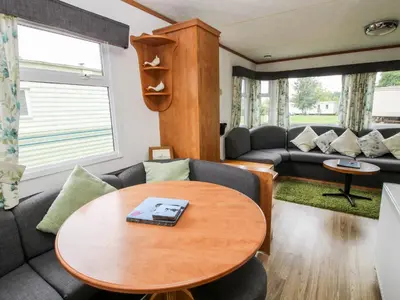 a living room with a table and a couch at 6 Old Orchard in Much Wenlock