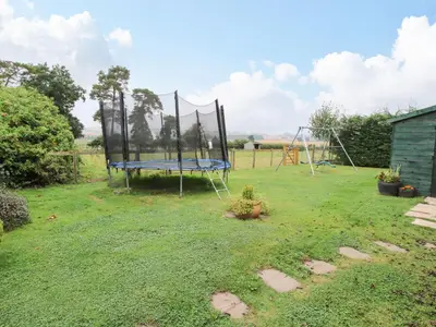 a playground with a trampoline in a yard at 10 Old Orchard in Much Wenlock