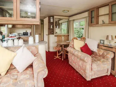 a living room with two couches and a kitchen at 10 Old Orchard in Much Wenlock