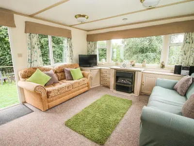 a living room with a couch and a tv at 8 Old Orchard in Much Wenlock