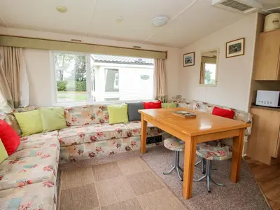 a living room with a couch and a wooden table at 3 Old Orchard in Much Wenlock