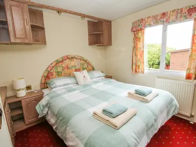 a bedroom with a large bed with towels on it at 2 Old Orchard in Much Wenlock