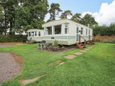 a green and white caravan in a yard at 5 Old Orchard in Much Wenlock