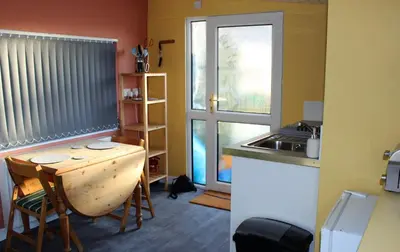 a small kitchen with a table and a sink at Redwood Lodge, Dee Valley Stays - cosy microlodge with detached private shower & WC in Corwen