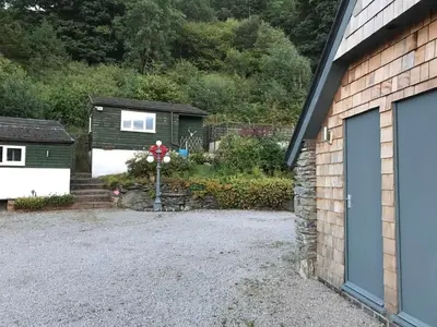 a driveway with a garage and a house at Redwood Lodge, Dee Valley Stays - cosy microlodge with detached private shower & WC in Corwen
