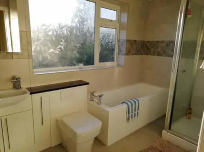 a bathroom with a tub and a toilet and a window at Country Home with Gardens in Newtown
