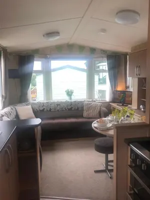 a living room with a couch and a table at Cosy holiday caravan minutes from the beach in Aberystwyth
