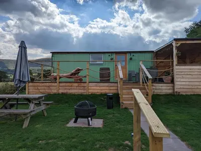 a house with a grill and a picnic table at Bespoke luxury huts with hot tubs. Located in the black mountains. in Llanveynoe