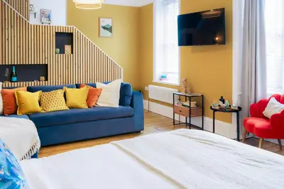 a living room with a blue couch and a red chair at Loft Fach in Tregaron