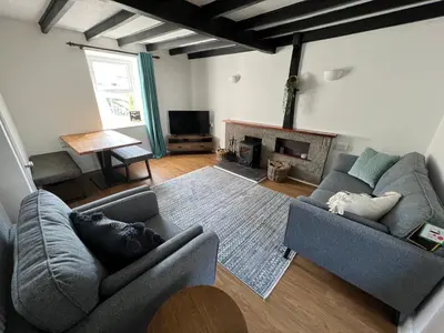 a living room with two couches and a fireplace at Escapism Wales Gwalia in Llanrhystyd