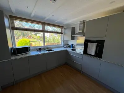 a large kitchen with a sink and a window at Escapism Wales Gwalia in Llanrhystyd