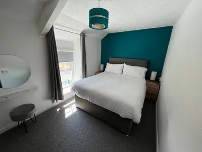 a bedroom with a large bed and a window at Escapism Wales Gwalia in Llanrhystyd