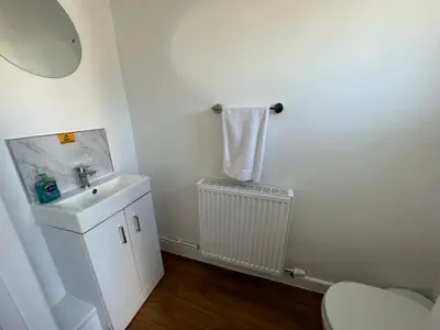 a white bathroom with a sink and a toilet at Escapism Wales Gwalia in Llanrhystyd