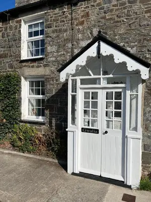 a white door on the side of a brick building at Escapism Wales Gwalia in Llanrhystyd