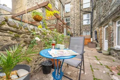 a blue table and a chair on a patio at 2 Bed in Barmouth oc-wag721 in Barmouth