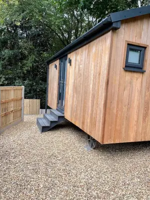 a wooden shed with a door and a staircase at Berwyn Lodge with private hot tub in Llangollen