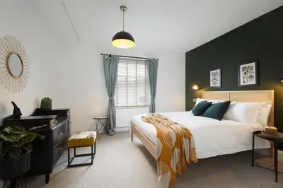 a bedroom with a large bed and a black wall at Kin Ludlow Rooms in Ludlow