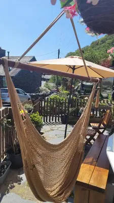 a hammock with an umbrella on a patio at The Granary Corris on the edge of the Dyfi Forest in Corris