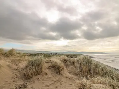 a sand dune with grass on the beach at Ystwyth 36 in Borth