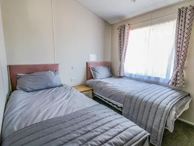 two beds in a small room with a window at Ystwyth 36 in Borth