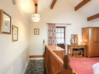 a room with a staircase and a desk and a window at Curlew Cottage in Bromlow