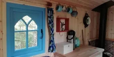 a room with a blue door and a window at Sapphire forest garden shepherd’s hut in Church Stretton