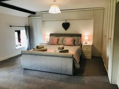 a bedroom with a large bed with two towels on it at Cobblers Cottage in Brecon Beacons in Brecon