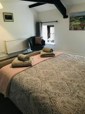 a bedroom with a large bed with two pillows on it at Cobblers Cottage in Brecon Beacons in Brecon