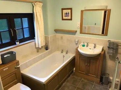 a bathroom with a bath tub and a sink at Cobblers Cottage in Brecon Beacons in Brecon