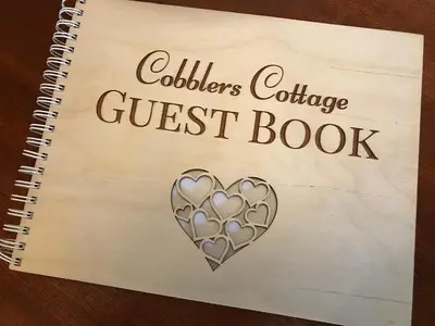 a spiral notebook with a silver heart on a guest book at Cobblers Cottage in Brecon Beacons in Brecon
